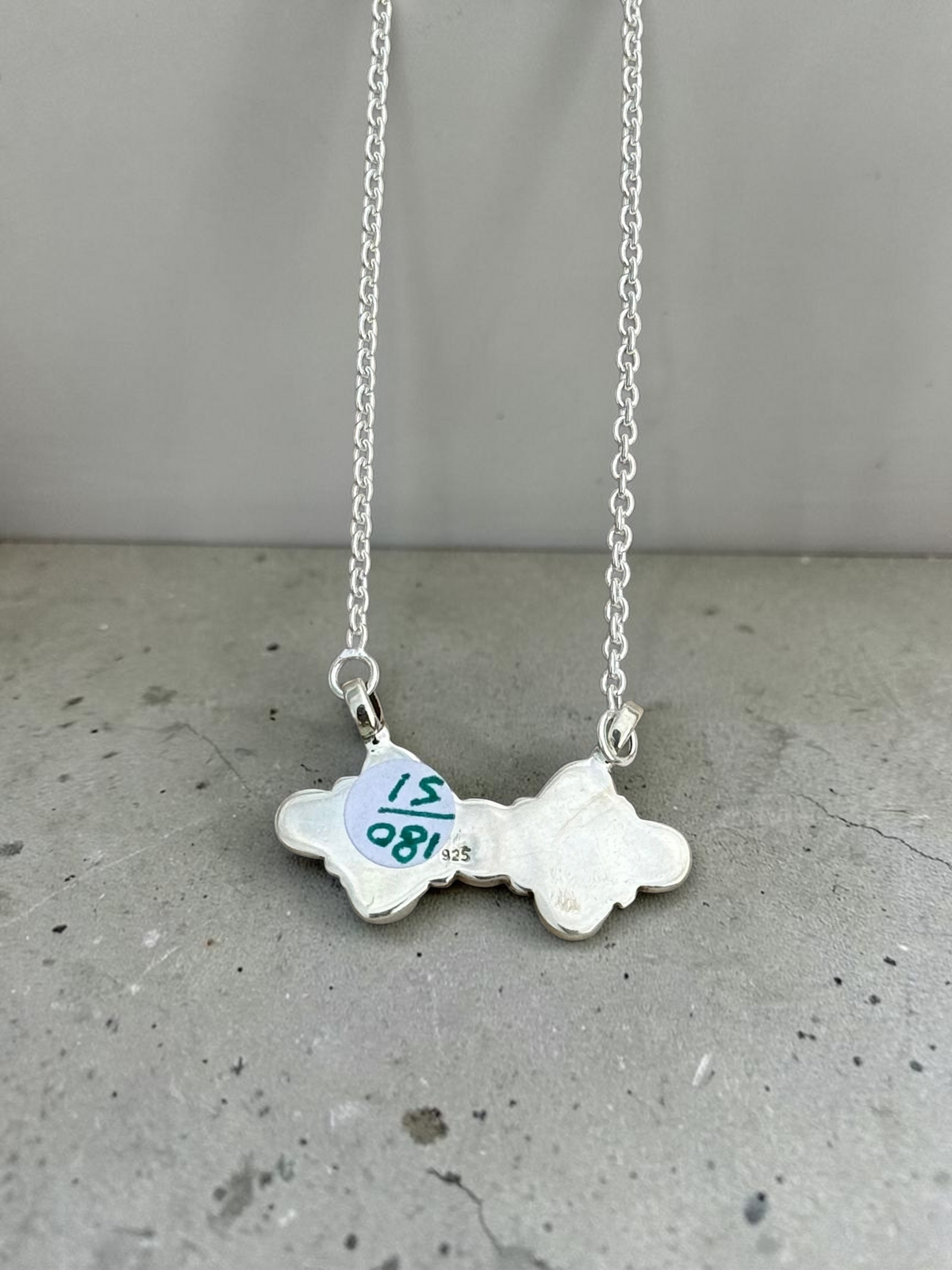 Hereford Valley sterling silver necklace featuring the back of a scalloped multi-stone pendant with 925 hallmark